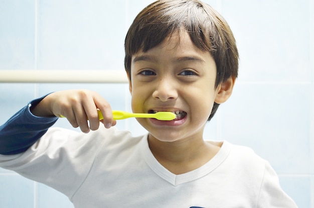 Garoto escovando os dentes com um sorriso | Foto Premium